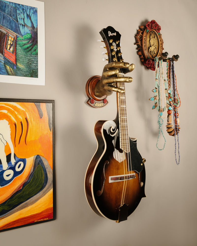 Mandolin in Jerry Garcia gold painted hand next to Wolf Garcia wall hanger in wood finish. 