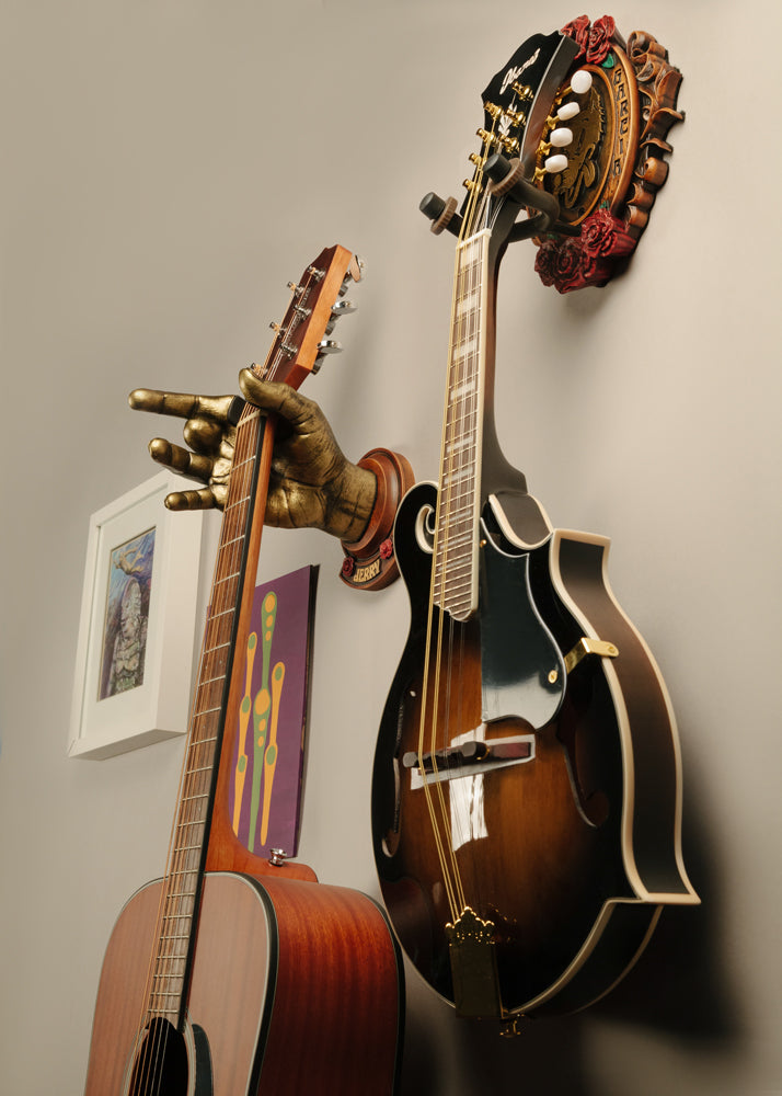 Acoustic guitar and mandolin hanging from Jerry Garcia of Grateful Dead instrument hangers. 