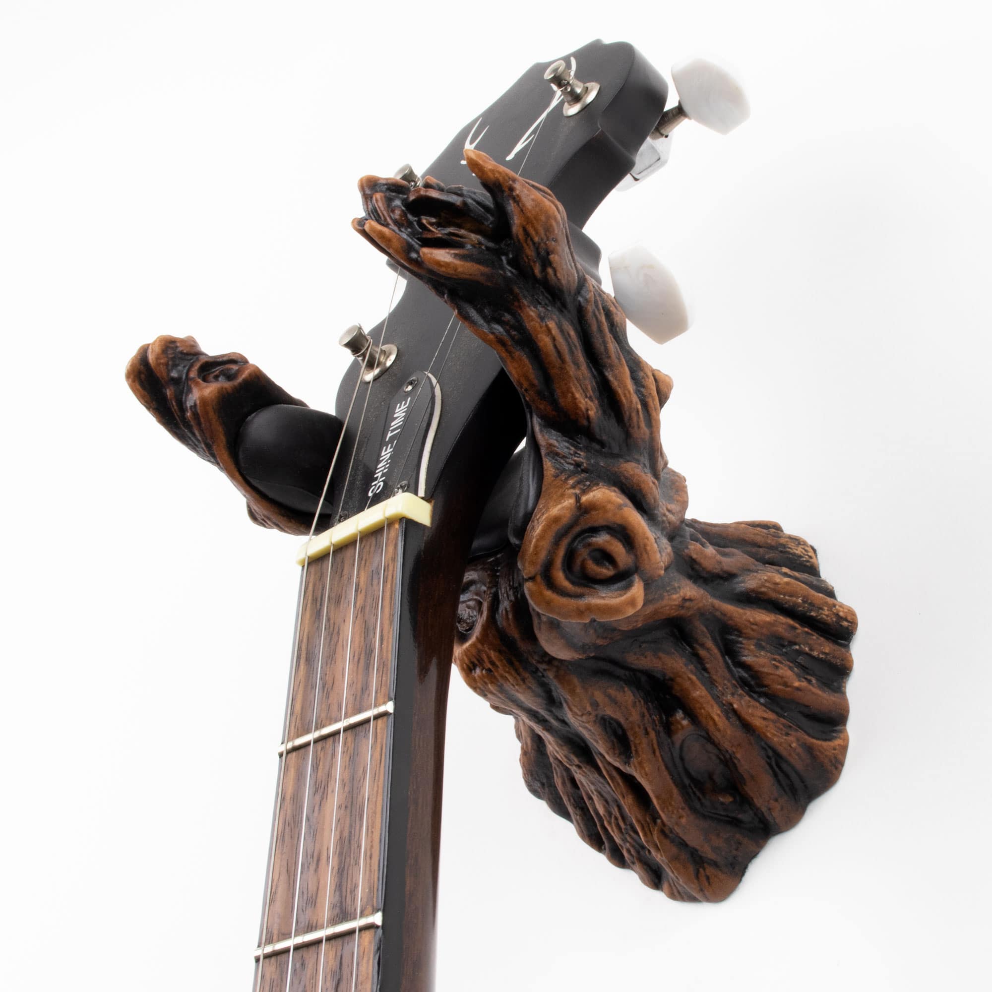 Tree branch wall hanger in brown finish for holding guitars