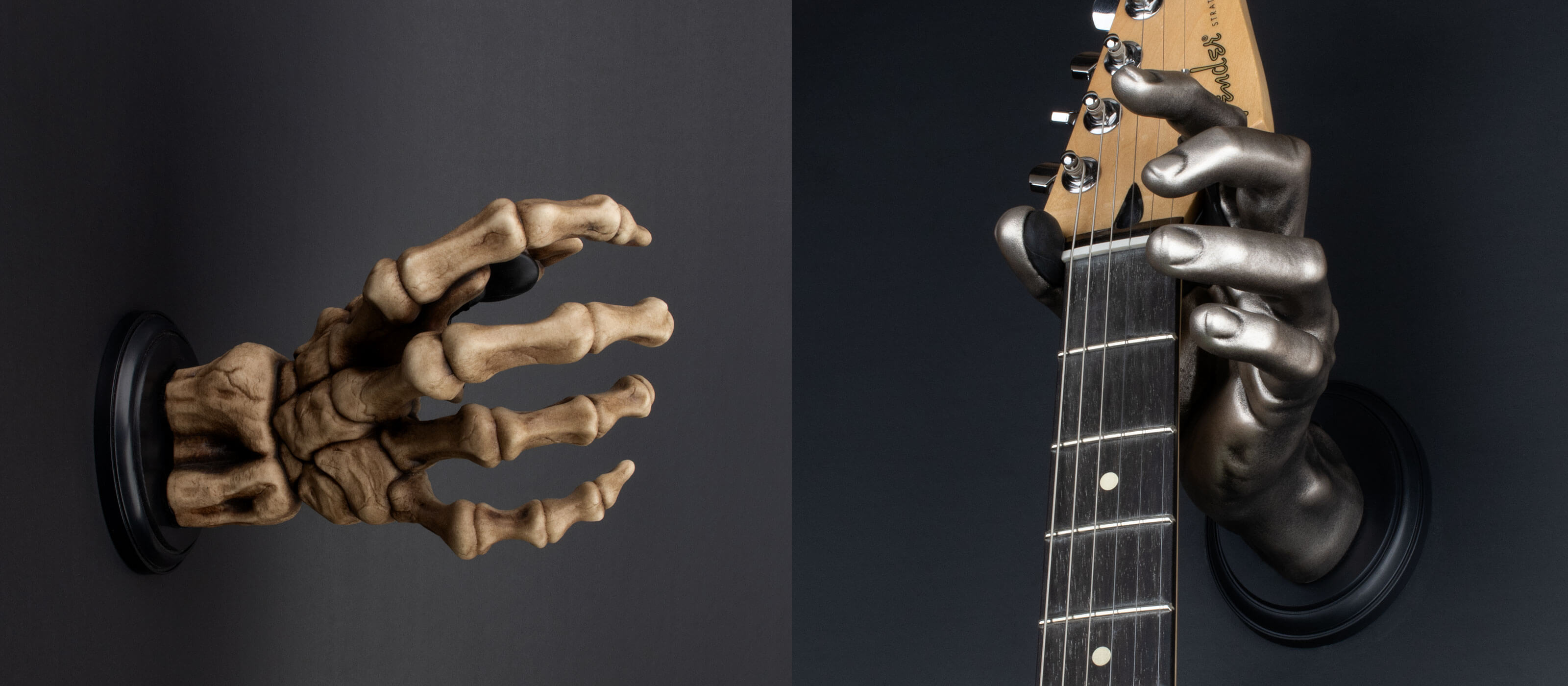 Guitar hangers in the shape of silver hand and skeleton hand holding an electric guitar on black background. 