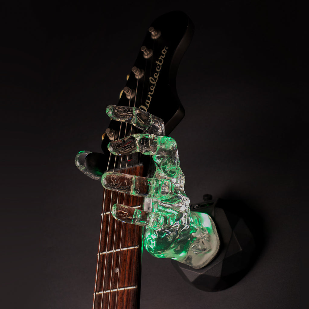 Green LED Crystal Clear Hand Guitar Hanger on black background holding guitar.