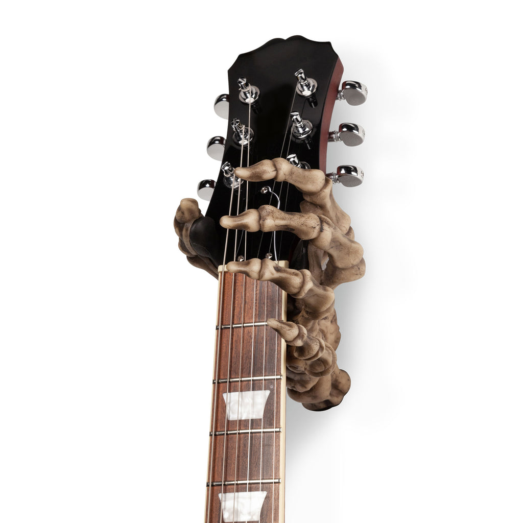 Skeleton hand guitar hanger holding guitar. 